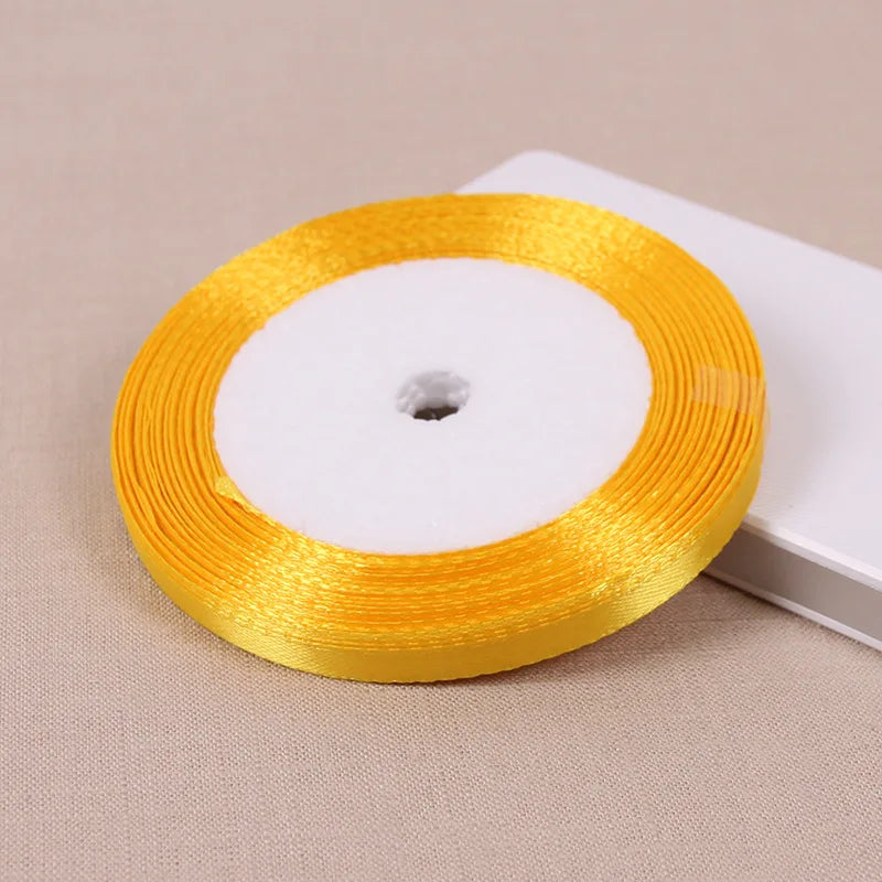 Eine Rolle goldgelbes Seiden-Satinband mit weißem Kern.