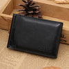 A black men's leather money clip wallet with magnetic closure resting on a wooden surface.