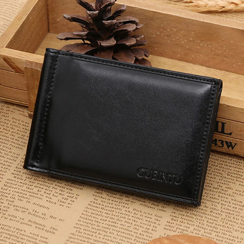 Black men's leather money clip wallet with magnetic closure resting in a wooden box.