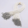 A bundle of white leather cord necklace with silver clasps and a thin gold string.