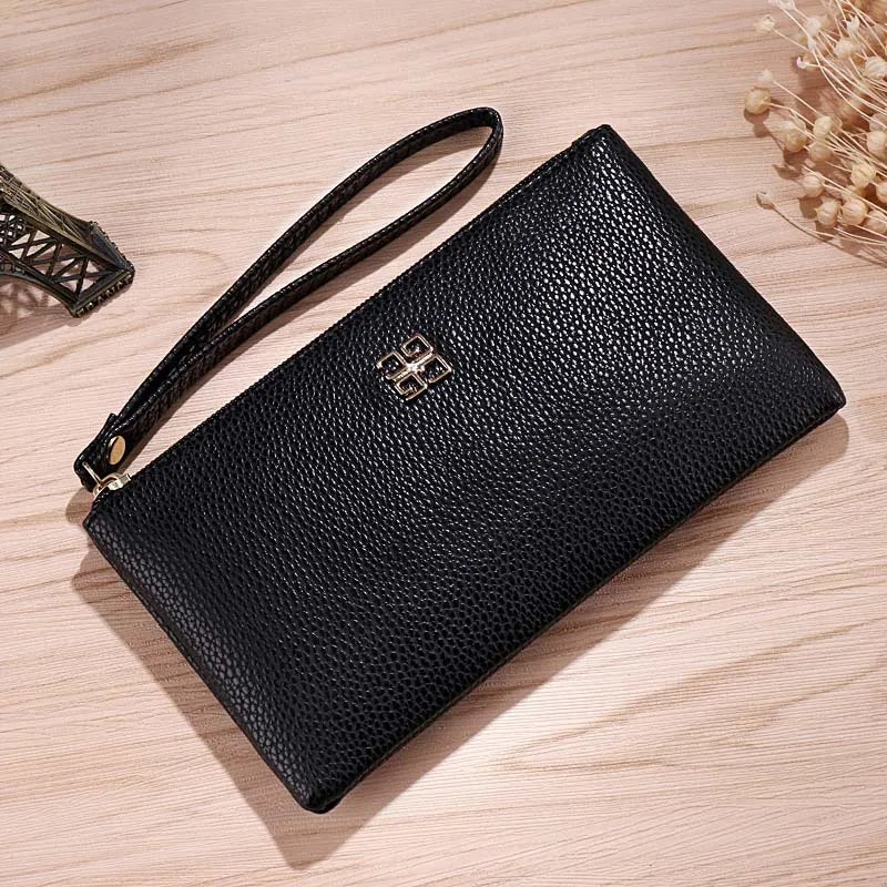 A black Litchi-Grain PU leather long wallet with a strap and a phone pocket resting on a light wooden surface.