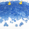A pile of small, bright blue decorative stone pebbles with a few yellow ducks scattered on top.