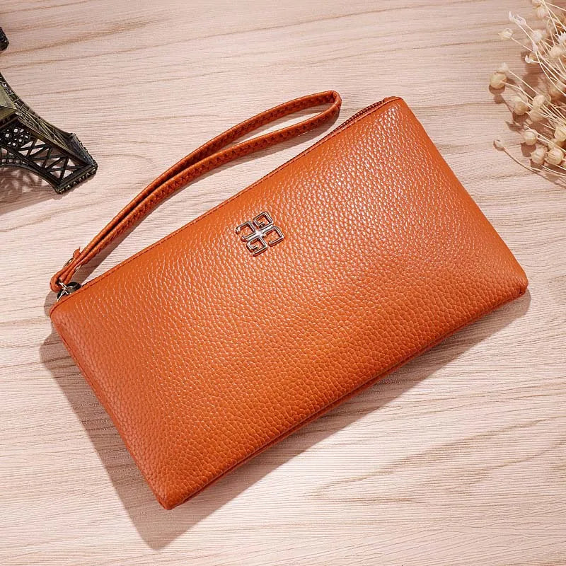 A tan Litchi-Grain PU leather long wallet with a strap is shown resting on a light wooden surface.