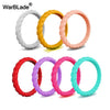A set of five braided silicone rings in white, yellow, pink, and blue colors displayed against a white background.