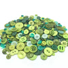 A pile of assorted eco-friendly wooden buttons in various shades of green and yellow.