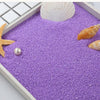 Purple decorative stone pebbles with a white seashell and starfish on a white tray