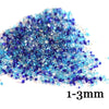 A pile of small, iridescent blue and purple decorative stone pebbles ranging from 1 to 3 millimeters in size.