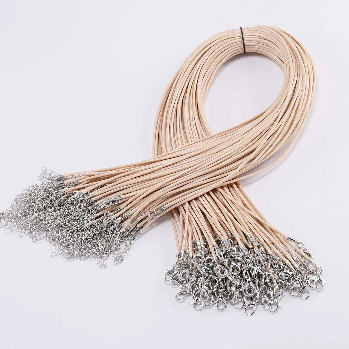 A bundle of thin, light beige leather cords with silver clasps coiled into a loop.