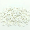 A pile of assorted white wooden buttons for sewing and crafts.