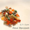 A pile of decorative stone pebbles in various shades of orange, green, and purple stones.