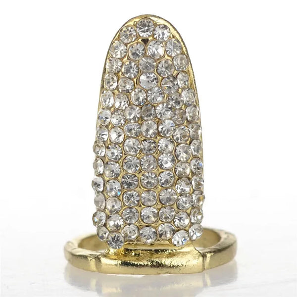 Bague à ongles dorée avec pavage de cristaux clairs en forme de couronne et nœud.