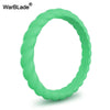A close-up view of a smooth, green braided silicone ring.
