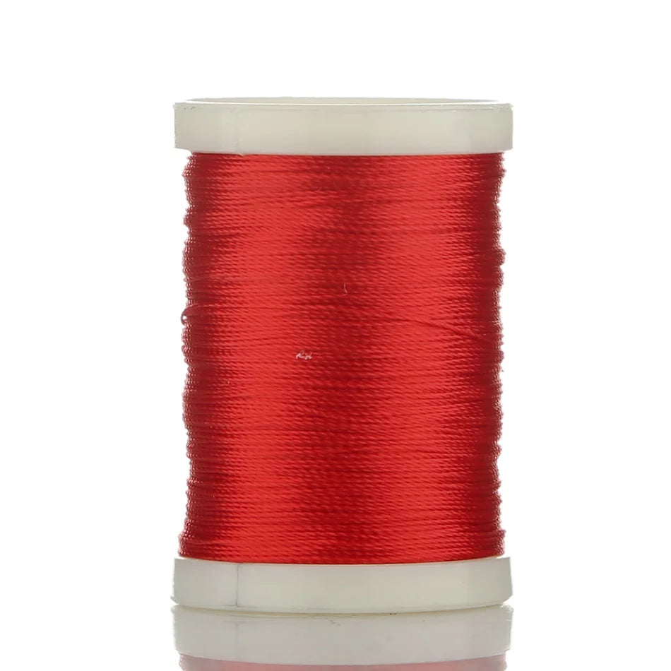 A spool of bright red braided polyester thread for guide tying and repairs.