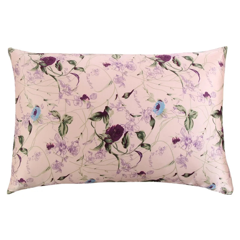 Quadratisches Seidenkissenbezug mit hellem rosa Hintergrund und lila-grüner Blumenmuster.