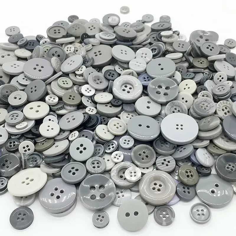 A close-up view of an assortment of small, round wooden buttons in various shades of gray and natural wood tones.