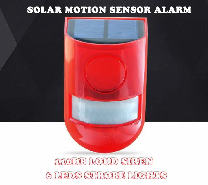 A red solar motion sensor alarm device with a lens and a visible solar panel on top.