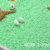 Green decorative stone pebbles with seashells and a pearl on a white surface