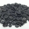 A pile of assorted black wooden buttons for sewing and crafts.