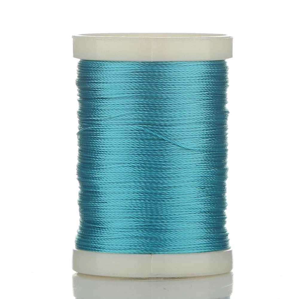 A spool of teal braided polyester thread for guide tying and repairs.