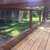 A wooden deck railing system featuring marine-grade stainless steel cable supports and posts.