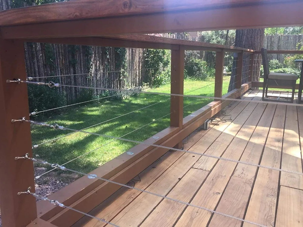 A wooden deck railing system featuring marine-grade stainless steel cable supports and posts.