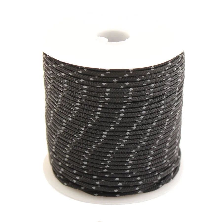 Spool of black high-visibility reflective paracord for camping and DIY projects