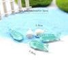 Five decorative stone pebbles shaped like sharks and dolphins are displayed on a blue surface.