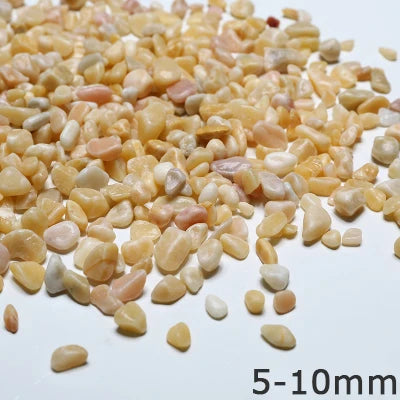 A pile of small, light-colored decorative stone pebbles in various shades of beige and pink.