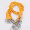 A bundle of bright orange leather cords with silver clasps, coiled and arranged for display.