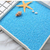 Blue decorative stone pebbles with a starfish and small white stones in a square container