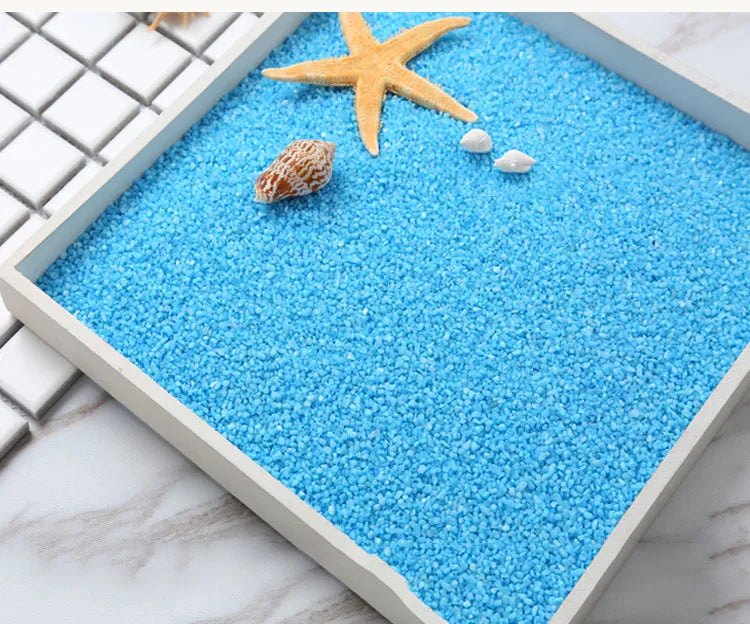 Blue decorative stone pebbles with a starfish and small white stones in a square container