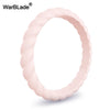 A close-up view of a pink braided silicone ring, designed as a hypoallergenic and sport-friendly wedding band.