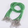 A bundle of green leather cord necklaces with silver clasps coiled together.