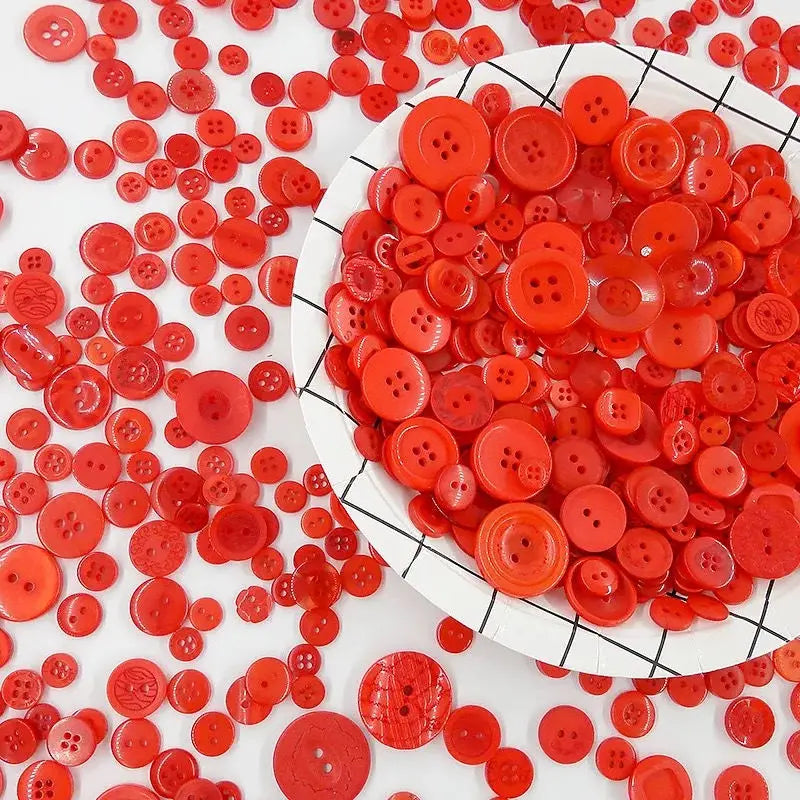 A close-up view of a large assortment of bright red wooden buttons scattered on a white surface.