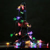 A lighted Christmas tree shaped like a tipi, decorated with colorful star lights.