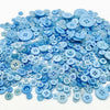 A pile of assorted light blue and sky blue wooden buttons for sewing and crafts