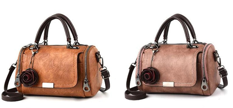 A tan leather crossbody shoulder bag with a floral pendant and dark brown strap.