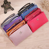 A collection of nine Litchi-Grain PU leather wallets in various shades of blue, pink, purple, and black laid out on a wooden 