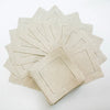 A stack of six natural linen hemstitch napkins folded and arranged on a white surface.