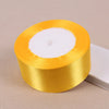 Eine Rolle goldgelbe Seiden-Satin-Borte mit weißem Kern.