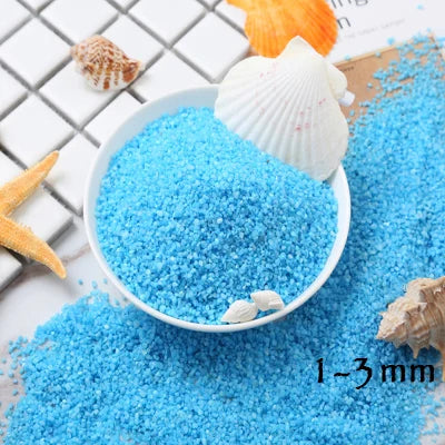 Bright blue decorative stone pebbles and seashells scattered on a white surface.