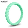 A close-up view of a light green braided silicone ring.