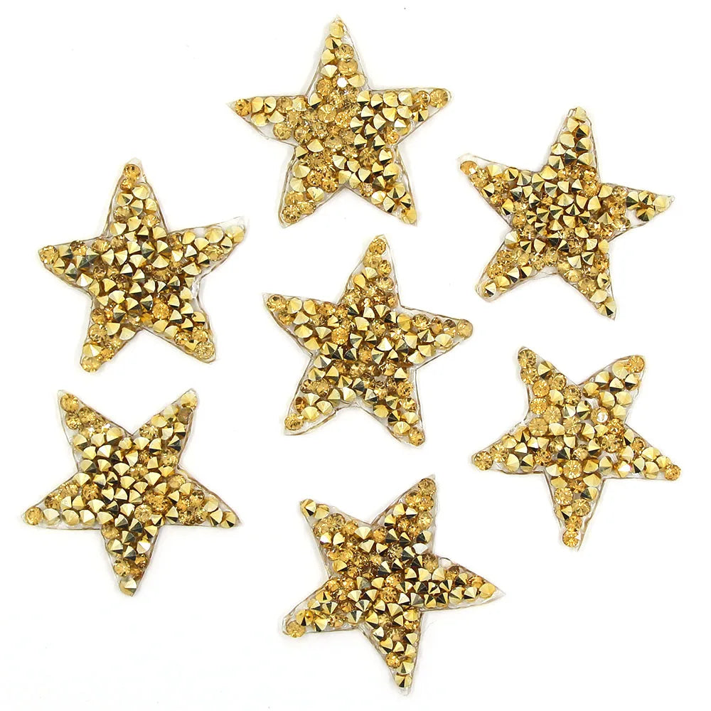 A collection of gold glitter rhinestone star patches for clothing and accessories.