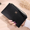 A black Litchi-Grain PU leather long wallet with a gold logo is shown being held on a wooden surface.