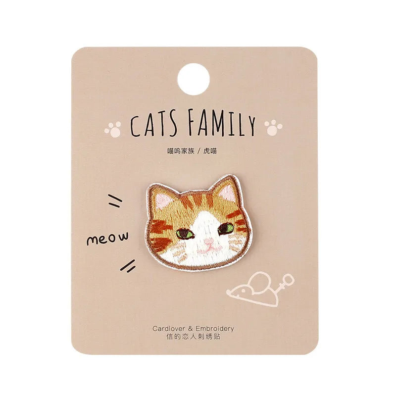 A beige tag featuring an embroidered cat face patch with the text Cats Family and a meow sound.