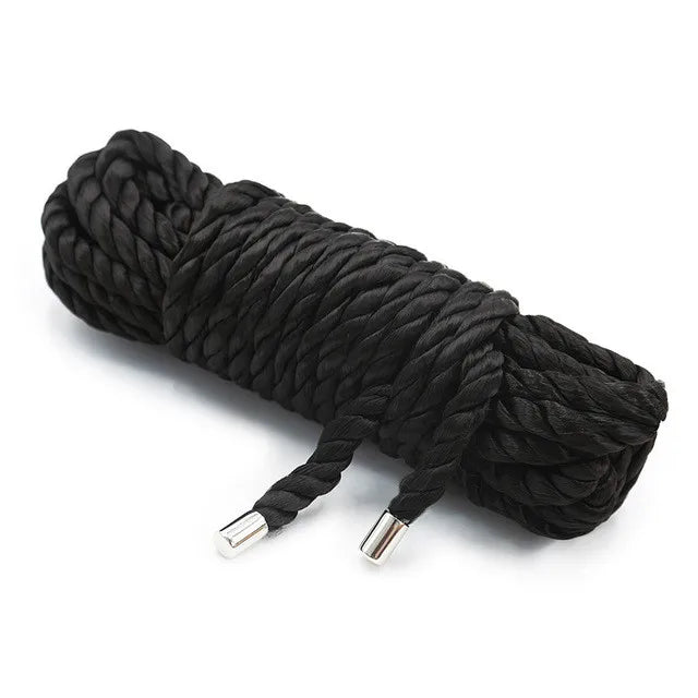 A coil of black Shibari bondage rope used for couples play.