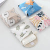 A collection of fabric cosmetic storage pouches featuring various patterns and designs like cats, leaves, and abstract shapes