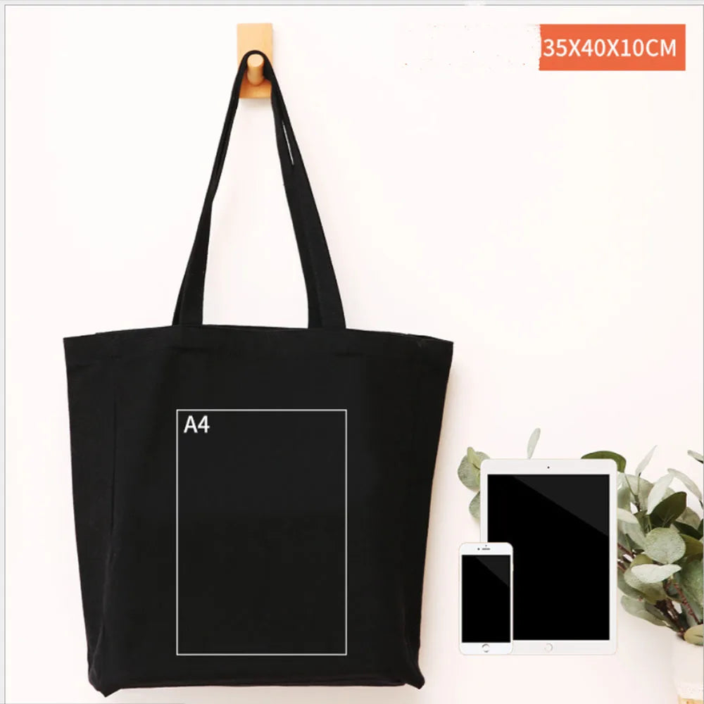 Black foldable canvas tote bag with an A4 sized print displayed next to a tablet and smartphone.