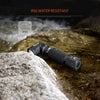 A black INIDRON 90° rotating hands-free LED flashlight is shown resting on a wet rock surface.
