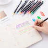 A collection of 24 gel pens in various pastel, metallic, neon, and glitter colors laid out on a white surface next to a noteb